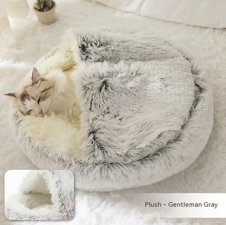 Fluffy gray pet bed with a cat inside on a soft white surface.