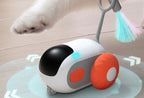 Cat playing with a robotic pet toy on a wooden floor.