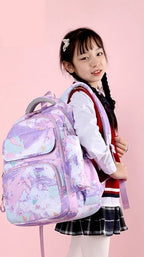A young girl wearing a school uniform carries a pastel purple and pink watercolor-patterned school backpack. T