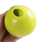 Hand holding a green ball-shaped object with a central hole on a white background