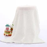 White towel on a white background with a bottle of dish soap in the corner.