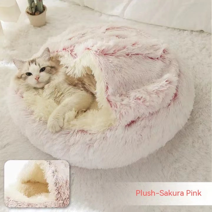 Cat lying in a plush Sakura Pink pet bed on a light-colored floor.