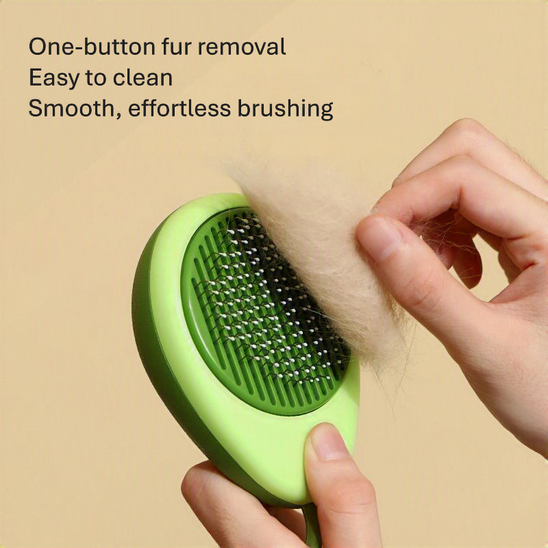 A green pet grooming brush being held by two hands, with a hand pulling out light-colored fur from the brush. Text on the top left reads 'One-button fur removal, Easy to clean, Smooth, effortless brushing' against a solid beige background.