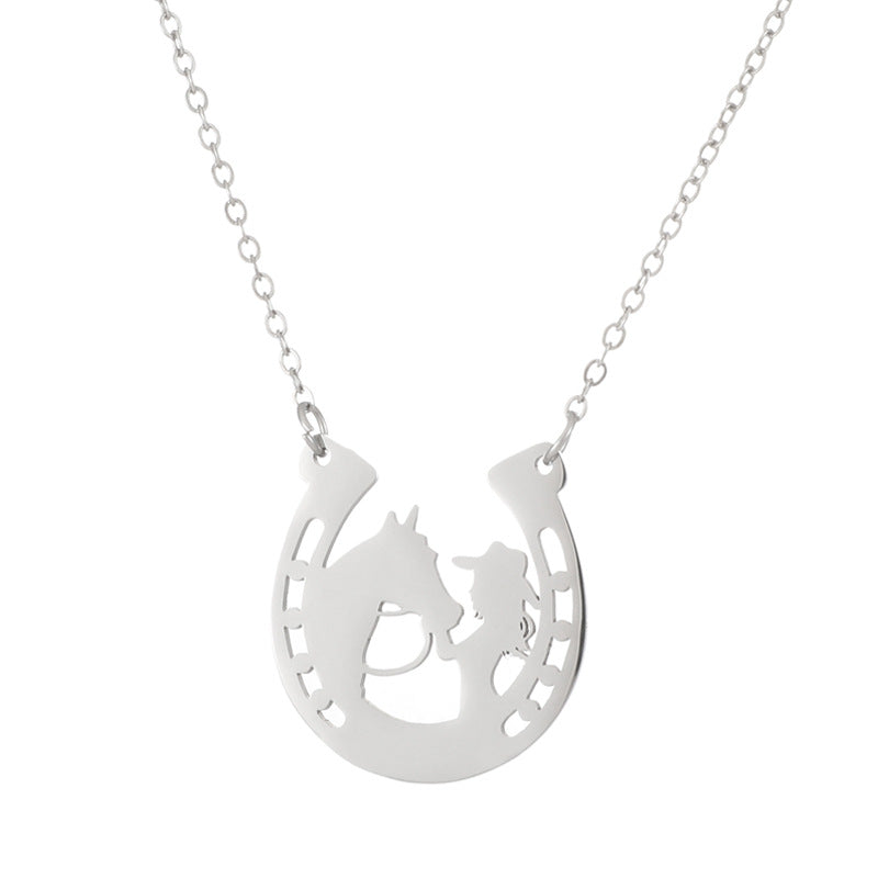 A silver necklace featuring a horseshoe-shaped pendant with a cutout silhouette of a horse and rider, suspended from a delicate silver chain against a plain white background.