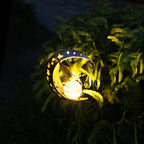 Decorative solar light shaped like a moon with stars on a plant at night.