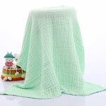 Green checkered tablecloth on a white table with a small model ship on a white background