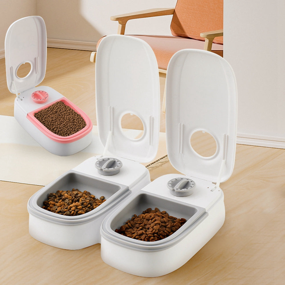 Pet food containers with open lids on a wooden floor.