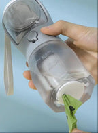 Portable water bottle held by a hand against a light blue background.
