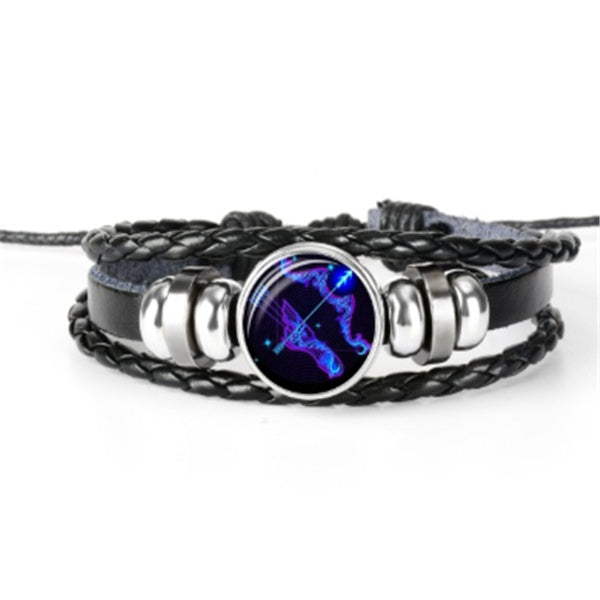 Bracelet with black braided design and silver accents featuring a blue and purple zodiac symbol on a white background.