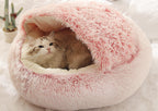 Cat lying in a pink plush pet bed on a white background.