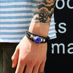 Person wearing a bracelet with a blue gemstone on a blurred background