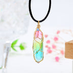 Necklace with a colorful crystal pendant on a blurred natural background