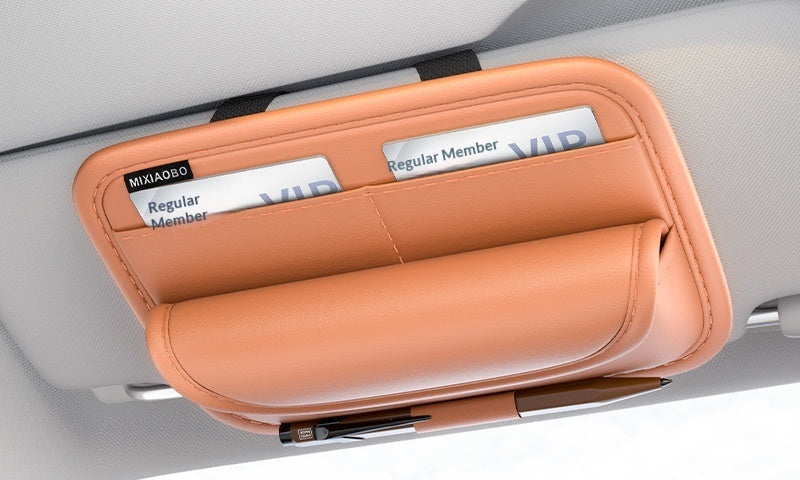 Car visor with an orange eyeglass case holding sunglasses and a card, with branding text on a white background.