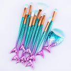 Set of makeup brushes with mermaid tail design on a white background