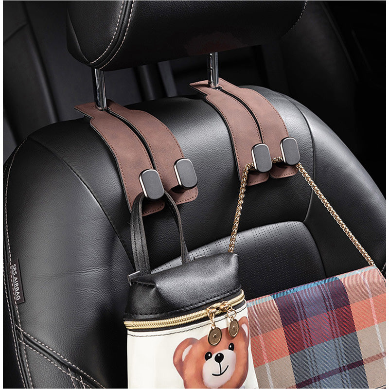 Car seat organizer with straps holding a bag and plaid item on a car seat.