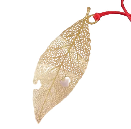 Gold leaf-shaped pendant with intricate designs on a white background.