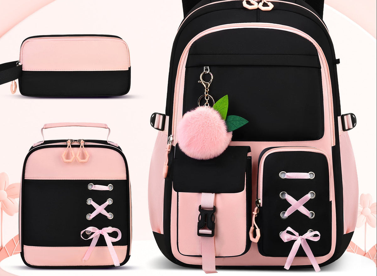 A black and pink backpack set shown on a light pink background, including the main backpack, a smaller matching lunch bag, a pen pouch, and a pen case. 