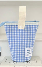 Blue checkered pouch with a white handle on a white surface