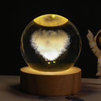 Glass sphere with a glowing heart on a wooden base against a dark background
