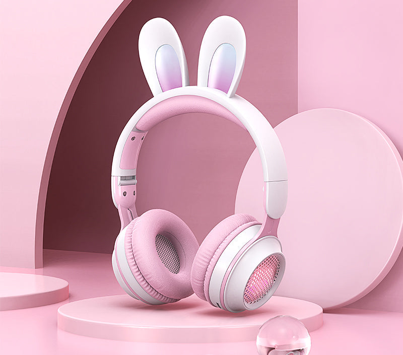 Pink and white headphones with bunny ears on a pink background