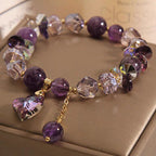 Multicolored beaded bracelet with a heart charm on a beige surface