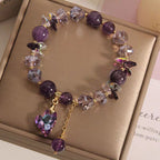Purple beaded bracelet with a heart charm on a gold box