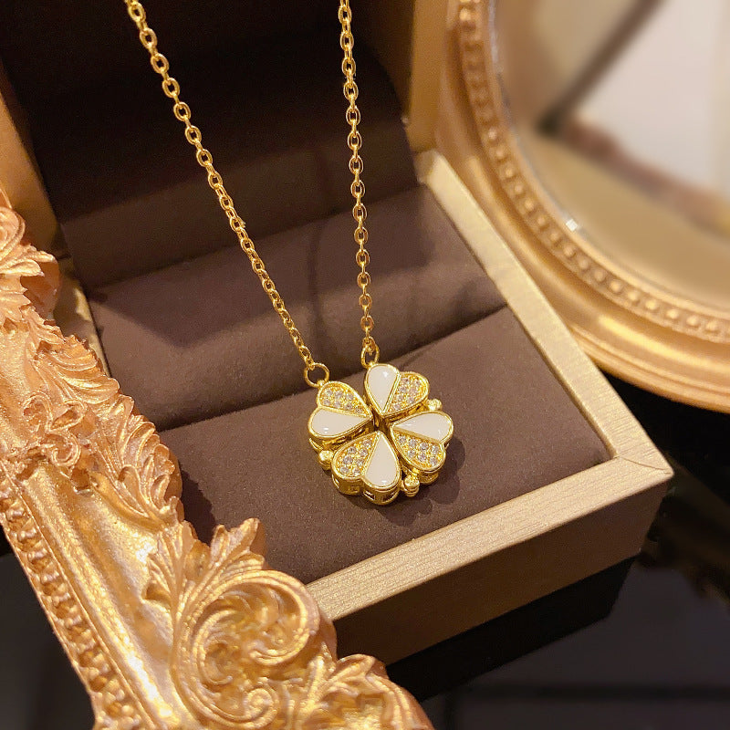 Gold necklace with a clover-shaped pendant in a jewelry box