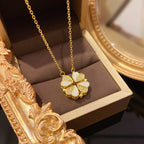 Gold necklace with a clover-shaped pendant in a jewelry box
