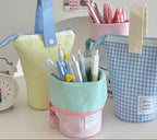 Colorful fabric containers with stationery items on a desk