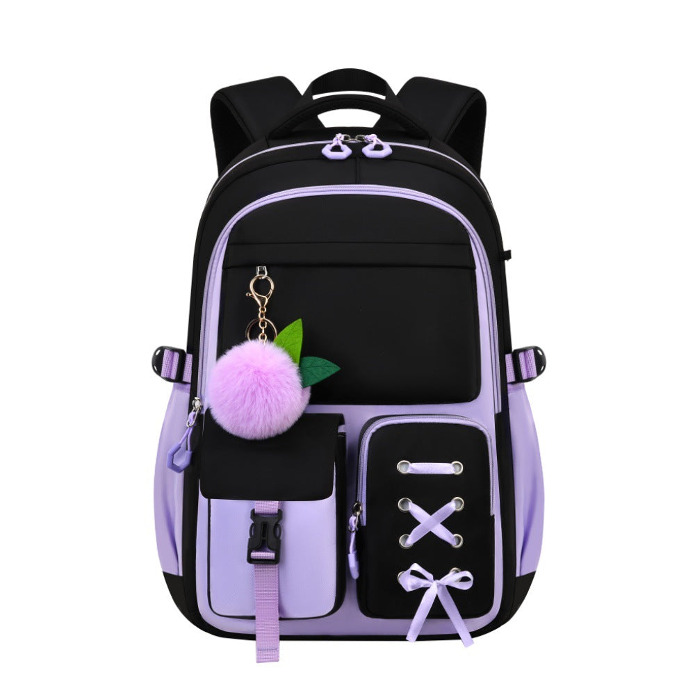 A black and lavender purple backpack with multiple front pockets, decorative lace-up detail, a fluffy pink pom-pom keychain, and green leaf accents, shown on a plain white background.