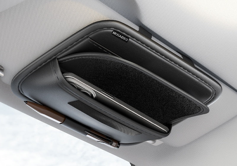 Car sun visor organizer with phone holder and pen tray, mounted on a car's sun visor.