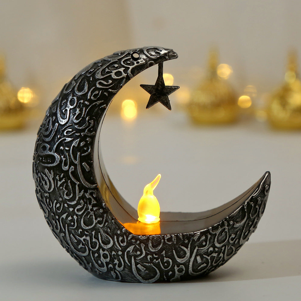 Decorative moon and star candle holder with a lit candle on a blurred background