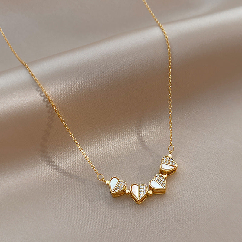 Gold necklace with heart-shaped pendants on a beige fabric background