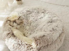Fluffy pet bed with a cat sleeping on it.