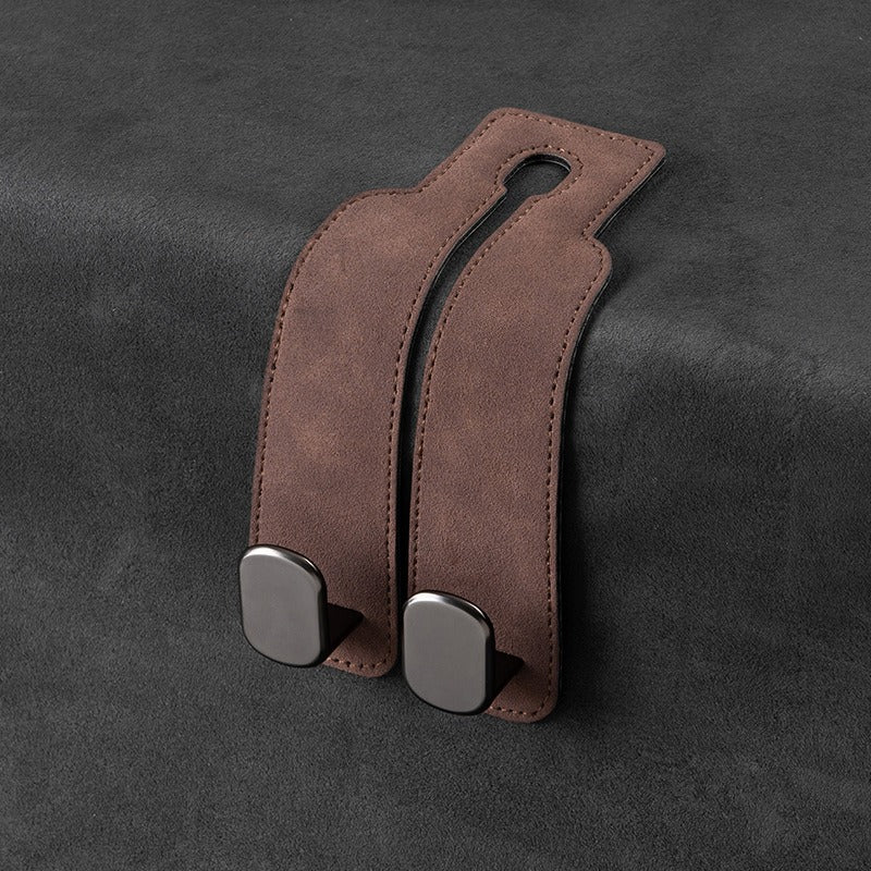 Brown leather strap with metal clasps on a dark gray background