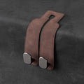 Brown leather strap with metal clasps on a dark gray background