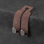 Brown leather strap with metal clasps on a dark gray background