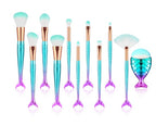 Makeup brushes with mermaid tail design on handles and a brush holder on a white background